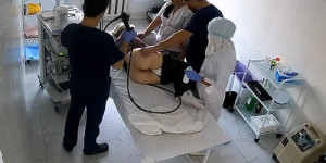 A patient lies on their side while a gastroenterologist inserts a colonoscope (Female colonoscopy SpyCam 45-47)